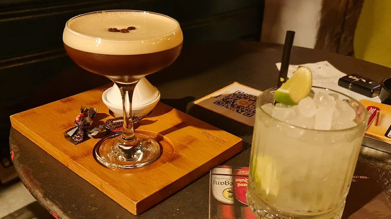 An espresso martini and another citrusy mixed drink sitting on a table at Botteghe Colletti, Palermo