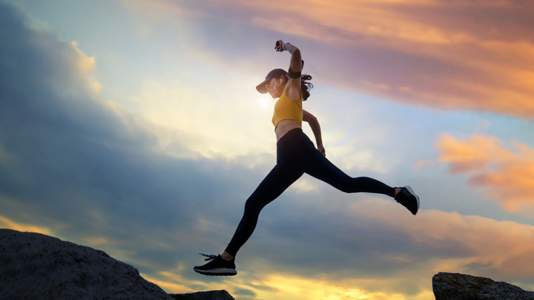 Runner leaping between rocks at sunset