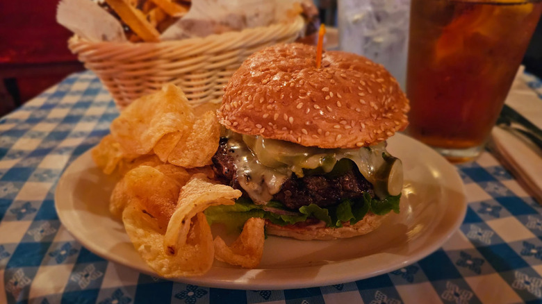 Burgers and potato chips on checkered tablecloth from Hugo's
