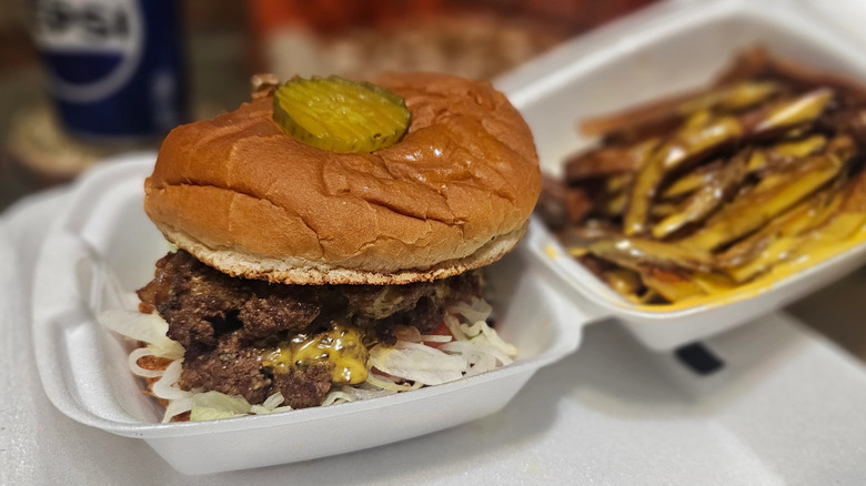 Cheeseburger with pickle slice on bun from Thee Burger Spot