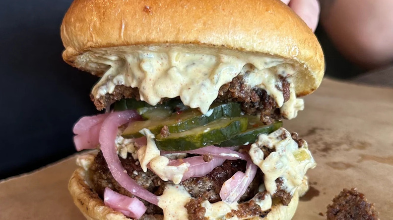 Cheese burger with pickles and pickled onions from Neon Pig