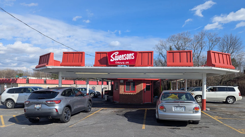 Cars parked in front of red Swensons Drive-In building