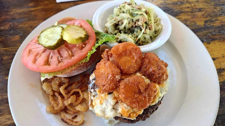 Burger with shrimp, coleslaw, and vegetables on side from Poe's Tavern