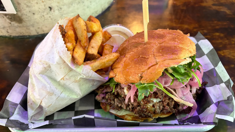 Lao burger with pickled onion, cilantro, and pork belly, and side of fries from Ox Burger