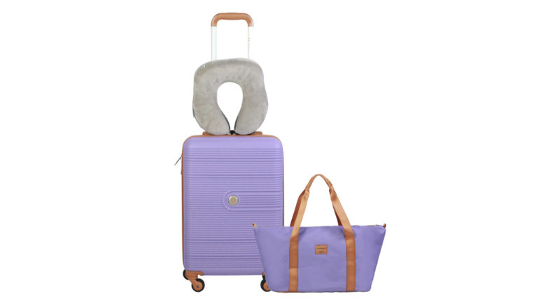 Mauve luggage and handbag with a grey neck pillow.