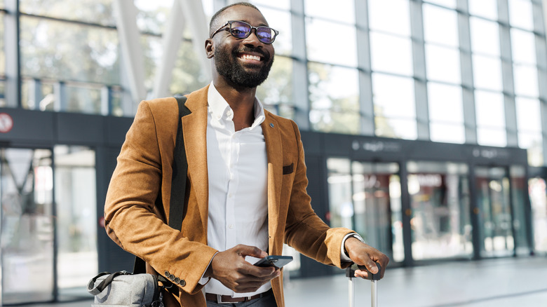 Business traveler walking into building with suitcase
