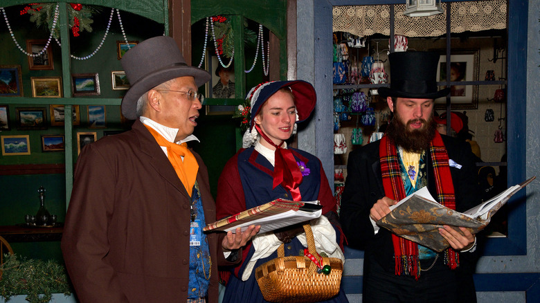 Carolers in front of a holiday vendor at The Great Dickens Christmas Fair in Daly City, California