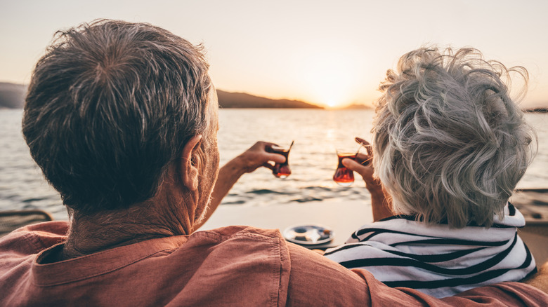 An elderly couple enjoys the sea view.