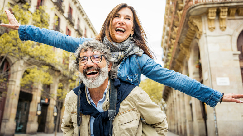 Happy senior couple walking on city street.