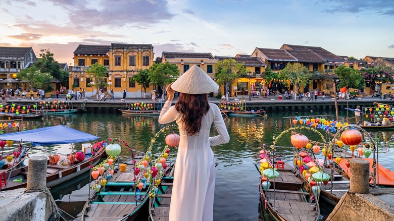 Woman with lanterned boats in Hoi An, Vietnam