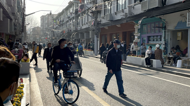 A local street in the Former French Concession, with plane trees and locals on electric scooters