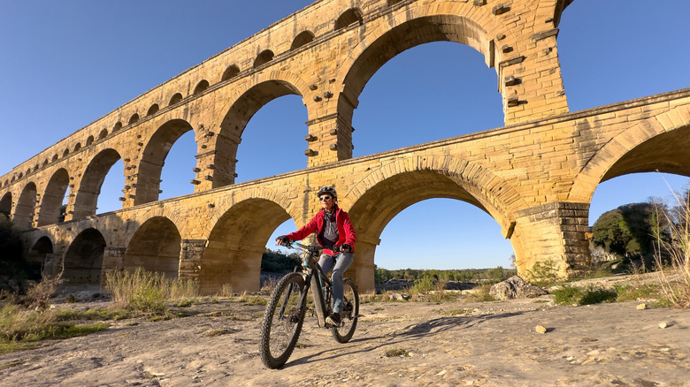 Woman mountain biking by the Pont du Gard near Nimes, France