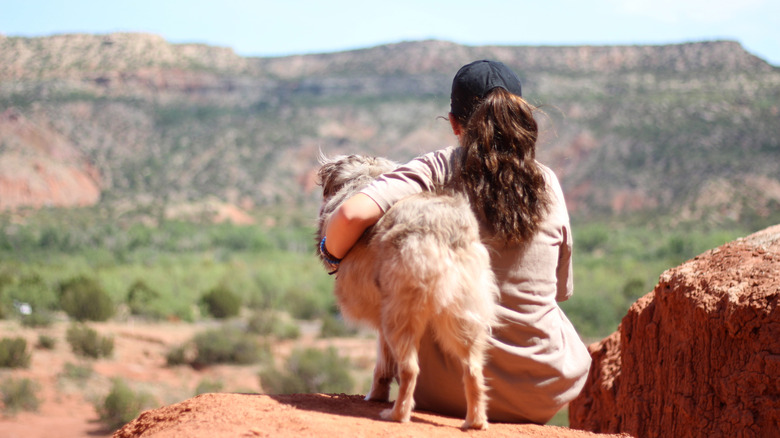 A woman sits with her dog at Palo Duro Canyon State Park
