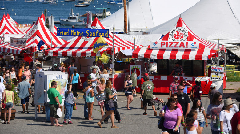 People walking by vendor tents at the Maine Lobster Festival