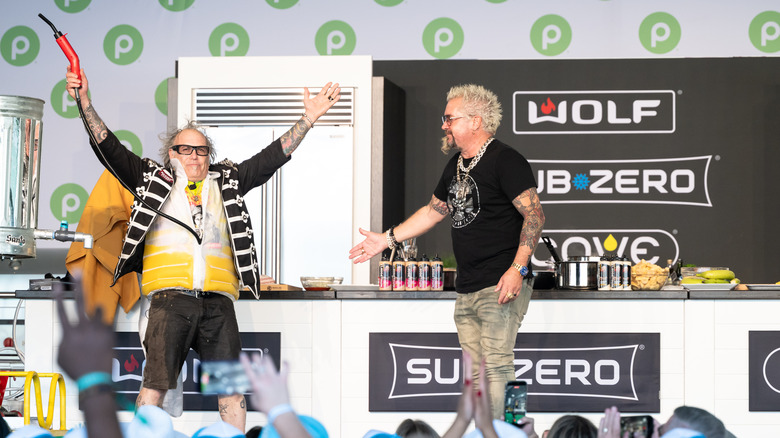 Guy Fieri on stage with a kitchen in the background at the South Beach Food & Wine Festival