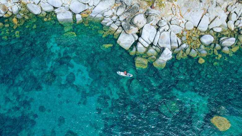 A paddleboarder on the clear, blue waters of Lake Tahoe.