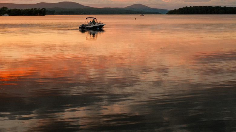 A lone boat sits on Lake Memphremagog at sunset