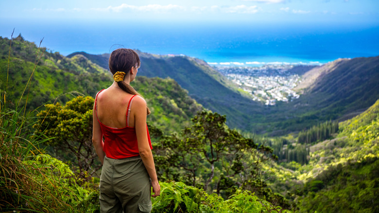 A hiker enjoys the panorama of O'ahu while climbing the Wiliwilinui ridge trail