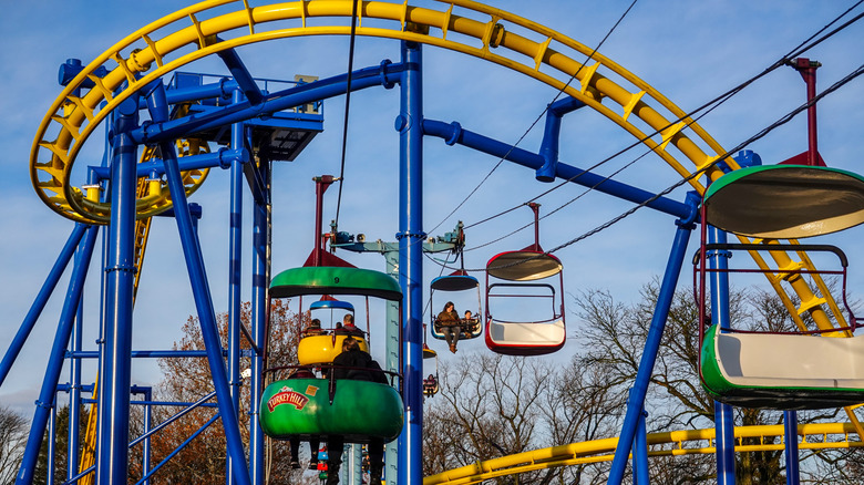 A theme park ride runs under a twisting rollercoaster