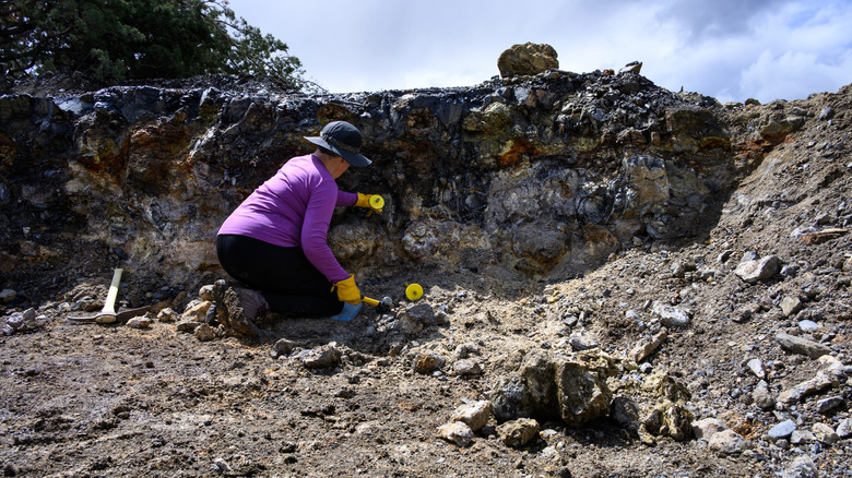 A woman using rockhounding tools in a mine