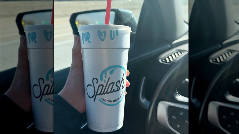 A cup with the Splash logo from Splash soda shop in a car