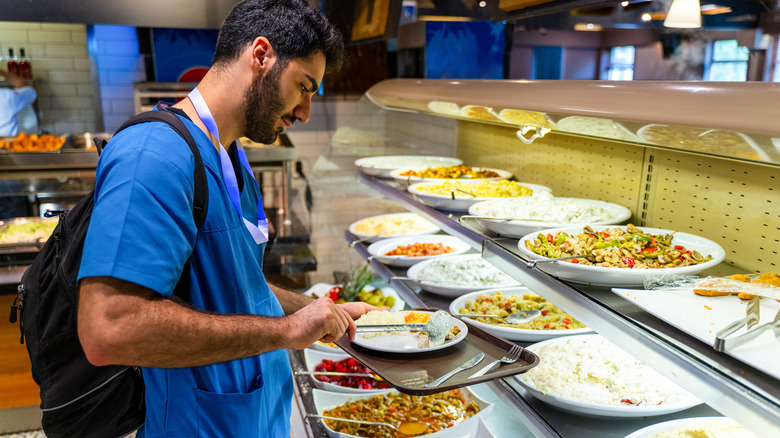 Man serving himself at a cafeteria buffet