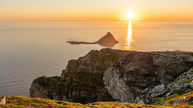 Sunset over Bleiksøya point in the water near cliffs in Norway