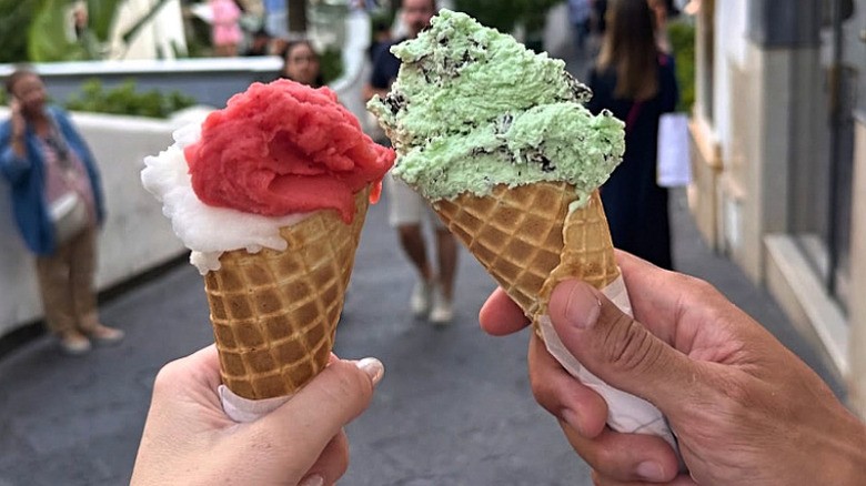 Two people holding up gelato cones in Capri.