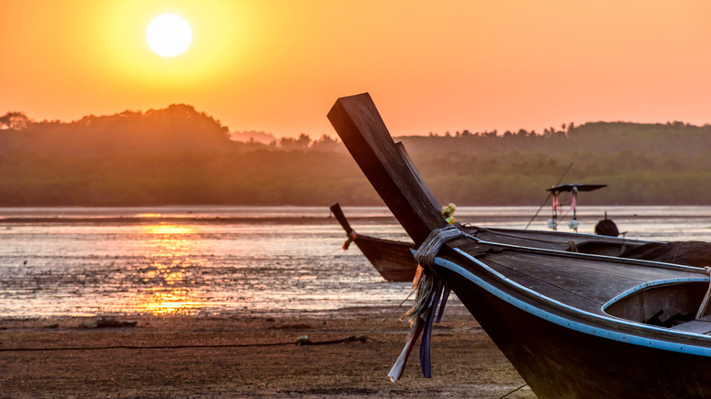 Long-tail boats at low tide at sunset on Ko Yao Noi