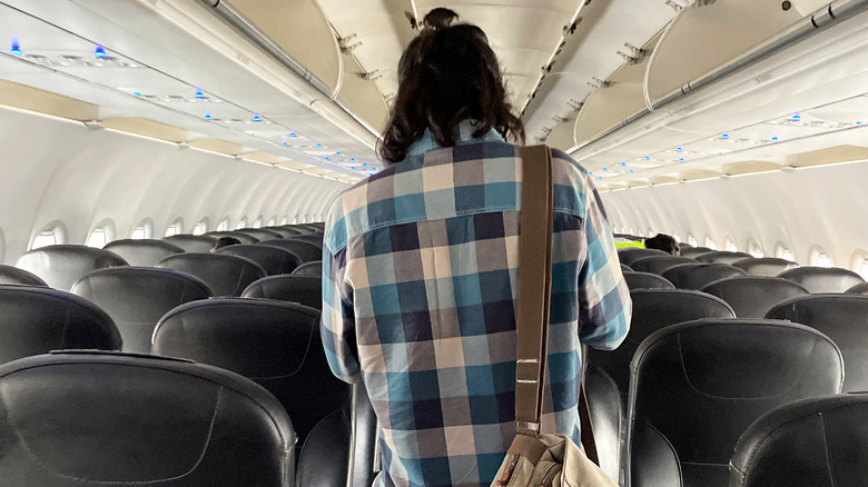 A person finding their seat in the plane