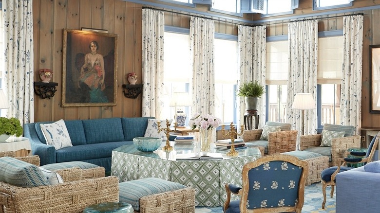 A living room filled with lush reclining chairs, curtains, and a glass surface table