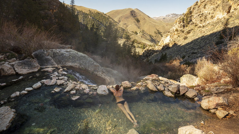 A young woman soaking early morning at Goldbug Hot Springs in Idaho.
