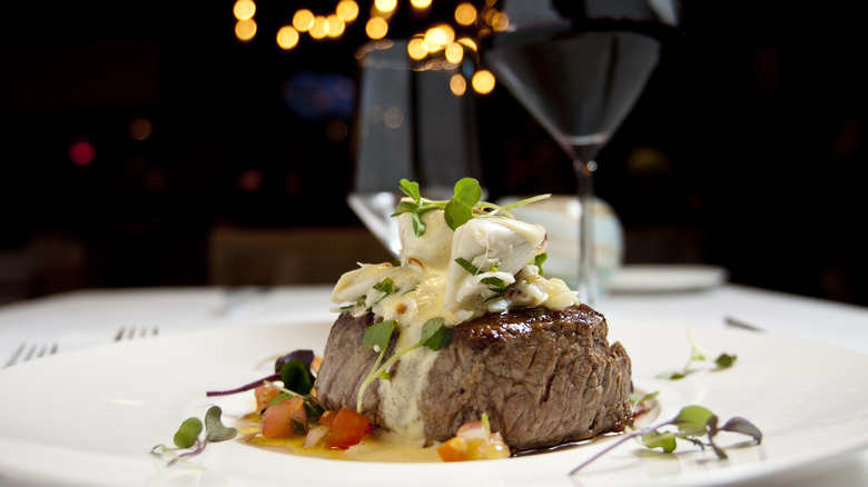Steak dinner and glass of wine at restaurant table