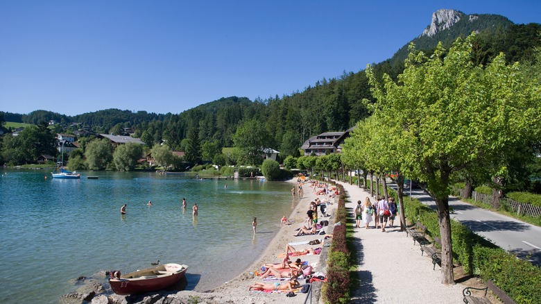 People swim and walk on Fuschlsee in Austria