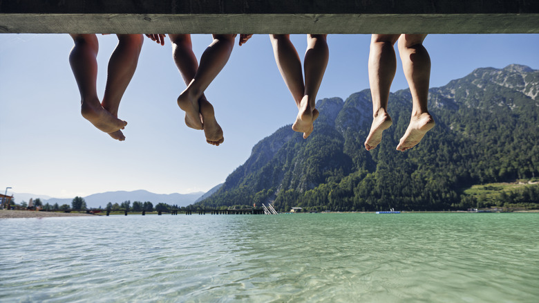 Four kid legs dangling off a dock