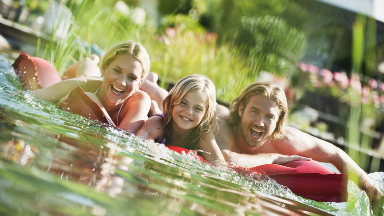 Two parents with child on float in pond