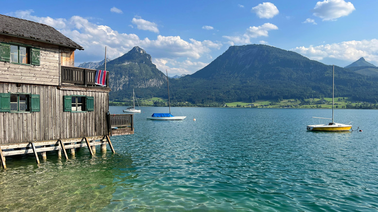 Wood building on stilts in a turquoise mountain lake
