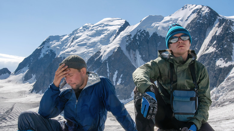 Two ill hikers on snowy mountain