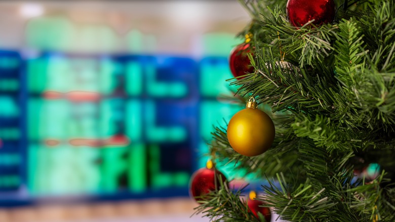 A Christmas tree in front of departure signs at the airport