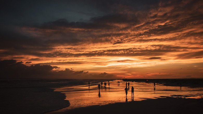 Beach with waves and storm clouds at sunset