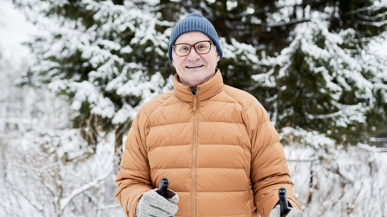 A senior man in the snow with ski poles