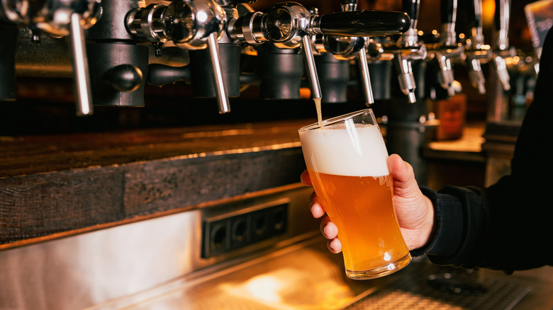 A bartender pouring a beer from a tap