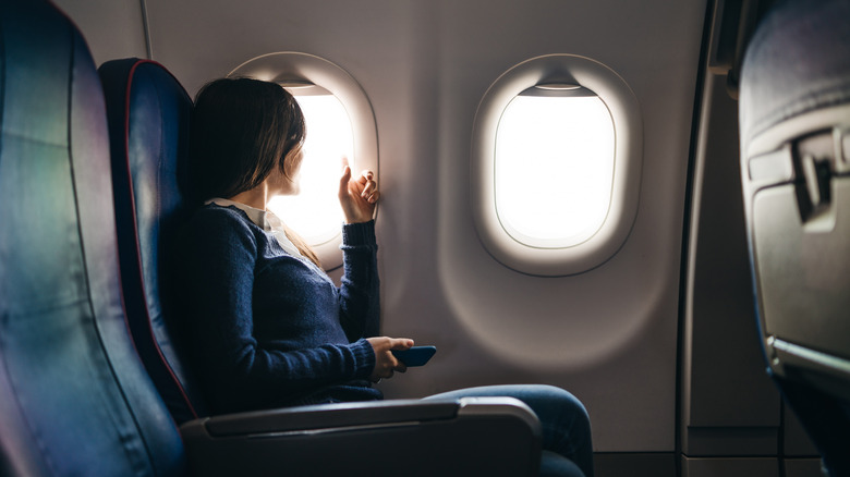 Woman seated in a window seat