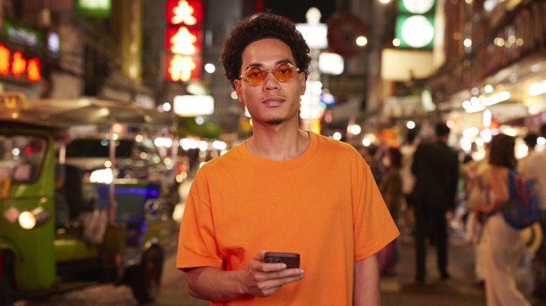 Guy using his phone in a night market