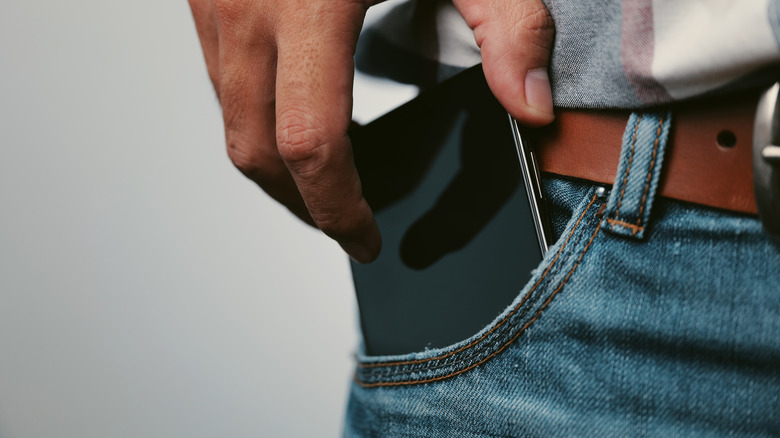 Person putting phone in their front pocket