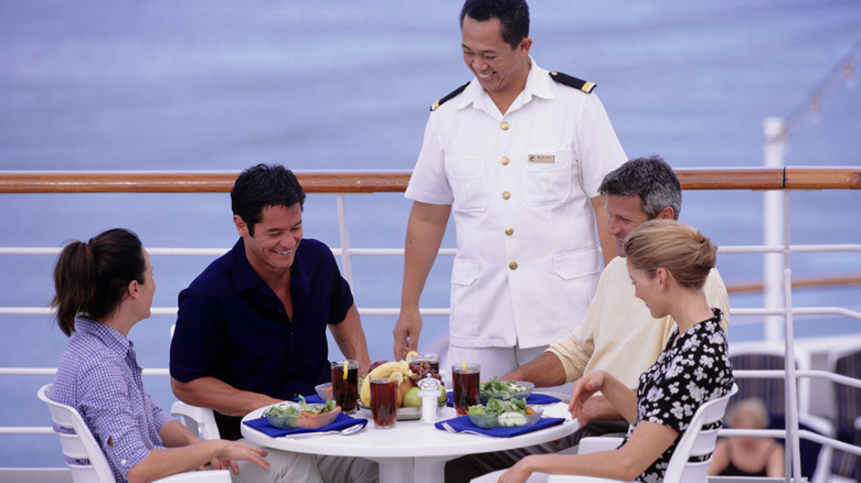 Cruise ship attendant talking with passengers