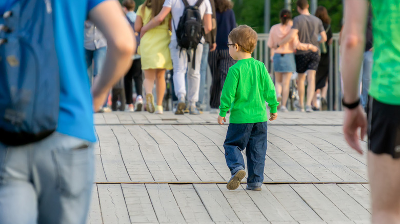 Little boy in a green shirt walking alone