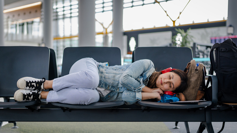 young traveler asleep on airport seats