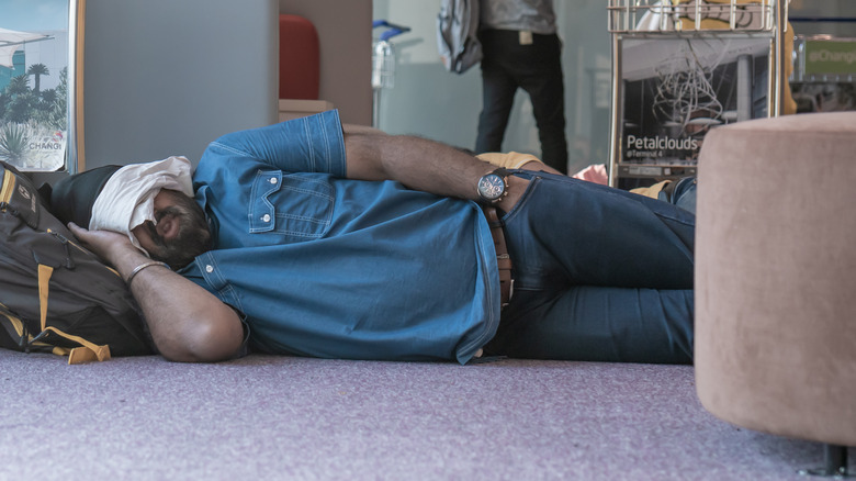 prepared traveler sleeps on airport floor