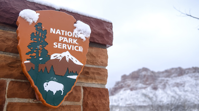 A National Park Service sign covered in snow